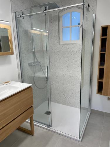 une douche avec une porte vitrée dans une salle de bain dans l'établissement Villa FALLA Spacieuse villa familiale avec piscine proche plage, à Saint-Cyprien