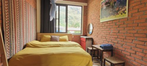 a bedroom with a bed and a brick wall at Du Gia View Homestay in Làng Cac