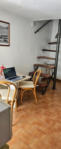 a living room with a table with a laptop on it at "A Ridosso" sul mare nel cuore del paese in Le Grazie