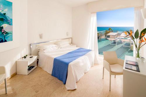 a bedroom with a bed and a view of the ocean at Hotel Caravelle Thalasso & Wellness in Diano Marina