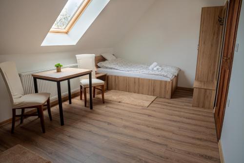 a small room with a bed and a table and chairs at Páca-hegyi szálláshely in Erdőhorváti