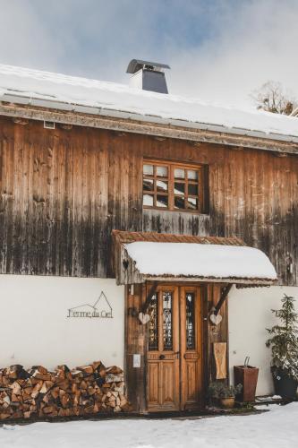 une vieille maison en bois avec de la neige sur le toit dans l'établissement Ferme du Ciel, à Samoëns