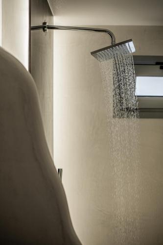 a shower with a shower head hanging from a ceiling at White Note Luxury Suites in Perivolos