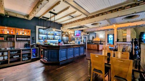 eine Bar in einem Restaurant mit einem Tisch und Stühlen in der Unterkunft Inn On The Coast in Portrush