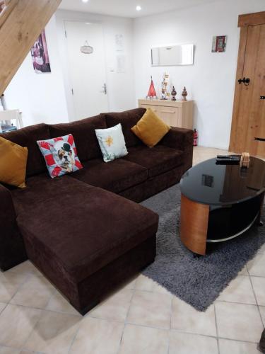 a living room with a brown couch and a table at Gite Albert in Scrignac