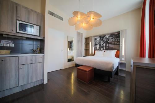 a hotel room with a bed and a kitchen at Aparthotel Adagio Strasbourg Place Kleber in Strasbourg