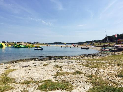 a beach with boats and people in the water at Seaview Kamenjak in Premantura