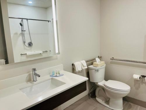 a white bathroom with a toilet and a sink at Quality Inn Kodiak in Kodiak