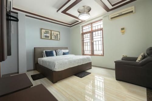 - une chambre avec un lit et un canapé dans l'établissement Getaway Experience Villa., à Dar es Salaam