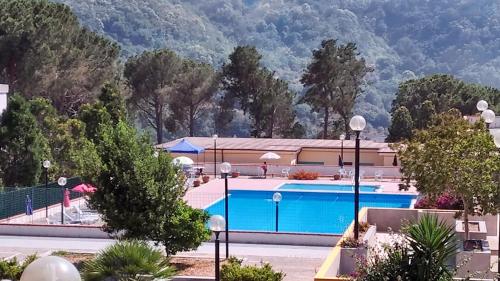 um resort com piscina e montanhas ao fundo em One bedroom apartement with furnished balcony and wifi at Montagnareale 5 km away from the beach em Montagnareale