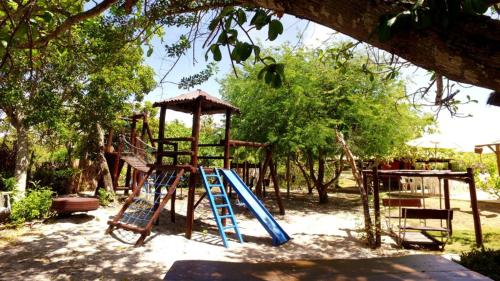 a playground with a slide and a swing at Pousada Bichelenga in Imbassai