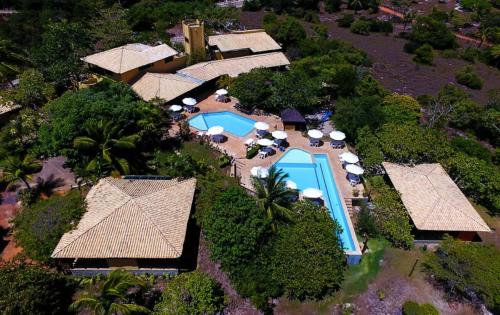 - une vue aérienne sur un complexe avec une piscine et des parasols dans l'établissement Pousada Bichelenga, à Imbassaí