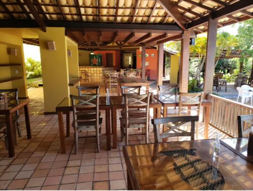 a patio with a wooden table and chairs at Pousada Bichelenga in Imbassai