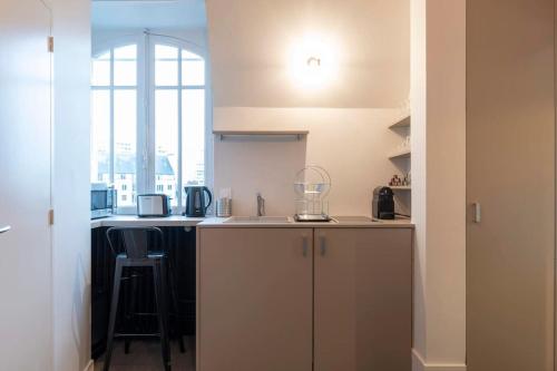 une cuisine avec un comptoir et un tabouret dans une pièce dans l'établissement Suite Cosy de charme - Hyper Centre - Second Lodge, à Rennes