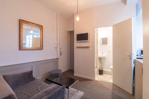 un salon avec un canapé et un miroir dans l'établissement Suite Cosy de charme - Hyper Centre - Second Lodge, à Rennes