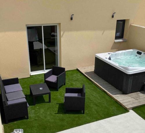 a jacuzzi tub in a room with chairs at Gîte du lavoir in Nonant