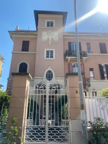 a pink building with a gate in front of it at Gelso in Rome