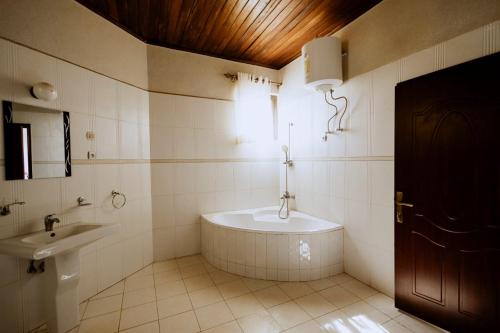 ADRIEL HOMES WOODLAND CENTEr في كيغالي: حمام مع حوض استحمام ومغسلة