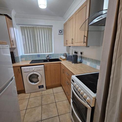 a small kitchen with a washing machine and a washer at Godricks Hollow House in Watford