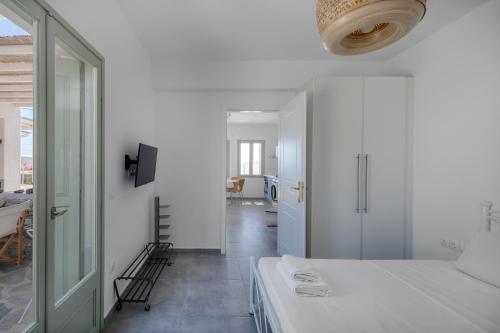 a white room with a bed and a hallway at Sea Houses SERIFOS in Rámos