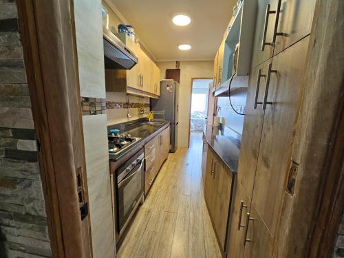 a kitchen with wooden cabinets and a stove at Departamento Frente al Mar in Viña del Mar