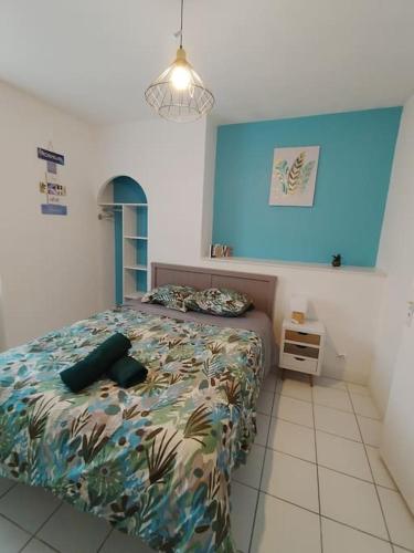 een slaapkamer met een bed en een blauwe muur bij appartement 2 Pièces in Limoges