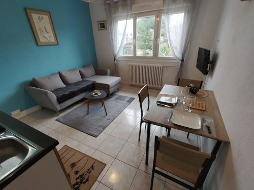 een woonkamer met een bank en een tafel bij appartement 2 Pièces in Limoges