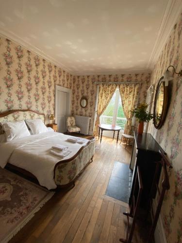 ein Schlafzimmer mit einem Bett, einem Tisch und einem Spiegel in der Unterkunft Chambre de Princesse avec Grande Salle de Bain in Blet