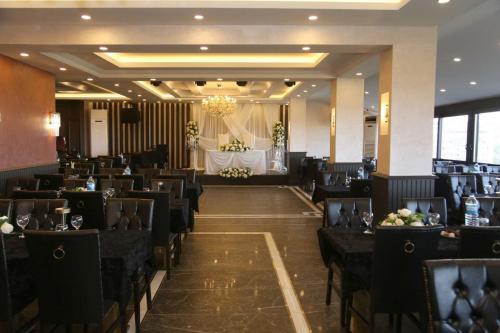 un salón de banquetes con sillas negras y mesa en BM HOTEL City en Samsun