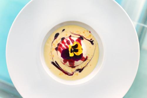 a cup of coffee with cream and a flower on top at Hotel Caravelle Thalasso & Wellness in Diano Marina