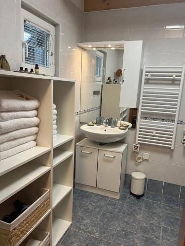 ein weißes Badezimmer mit einem Waschbecken und einem Spiegel in der Unterkunft Bella Mura Nature House I26 in Podčetrtek