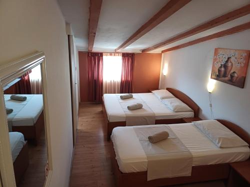 Habitación de hotel con 3 camas y ventana en Accomodation Suran, en Rovinj