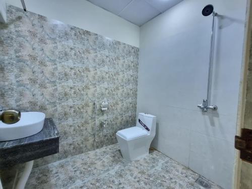 a bathroom with a toilet and a sink at The Life Style Lodges opp Centaurus Mall in Islamabad