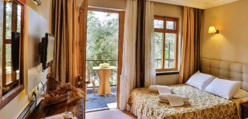 a bedroom with a bed and a window at Club Hotel Gultur in Kucukkuyu