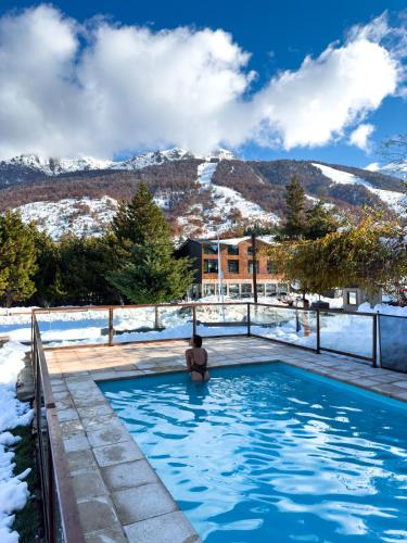 a woman sitting in a swimming pool in the snow at Complejo Base 41 in San Carlos de Bariloche