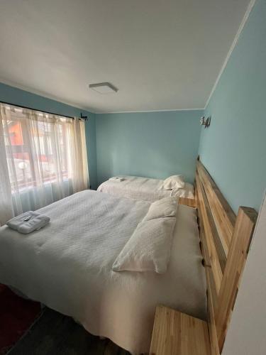 a bedroom with a large bed with a window at Cabañas Español Coyhaique in Coihaique