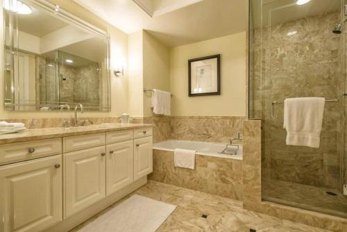 uma casa de banho com uma banheira, um lavatório e um chuveiro em Private condo hotel at Four Seasons Brickell em Miami