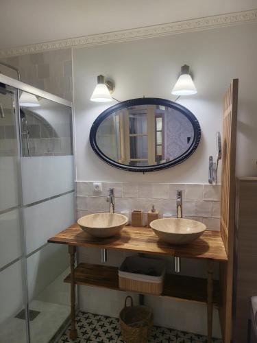 a bathroom with two sinks and a mirror at Fontevraud Les Chambres in Fontevraud-l'Abbaye