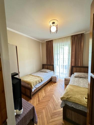 um quarto de hotel com duas camas e uma televisão em Warm Flat em Gonio