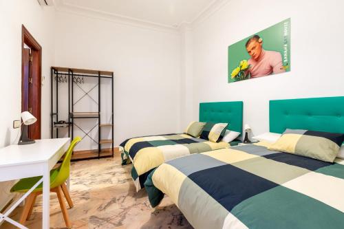um quarto com 2 camas, uma mesa e uma secretária em Banana Gay House - Only Men em Sevilha