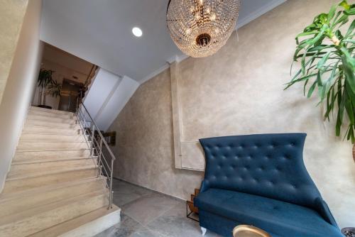 a living room with a blue couch and stairs at Hotel Avenue in Sunny Beach
