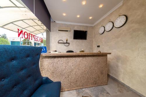 a waiting room with a counter and two clocks on the wall at Hotel Avenue in Sunny Beach