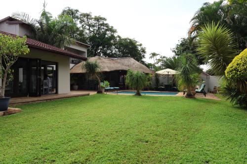 a house with a yard and a swimming pool at Hhusha Hhusha in Malelane