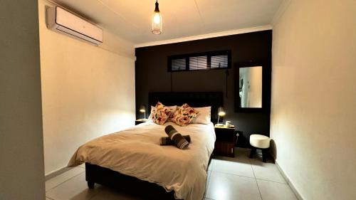 a bedroom with a bed with a black wall at Micro Urban Oasis in Pretoria