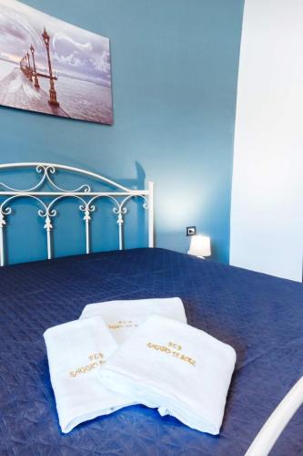 a blue bedroom with a bed with two white pillows at Appartamento Alla Marmora Porto Empedocle in Porto Empedocle