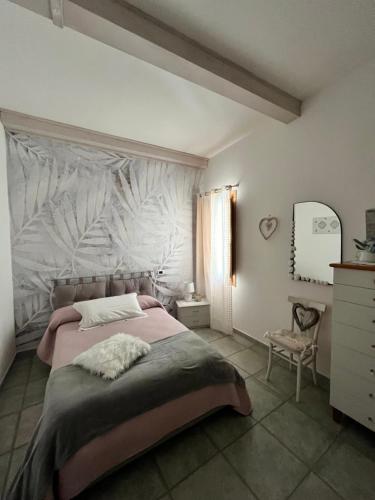 a bedroom with a large bed with a white wall at B&B Roseddu in Bitti