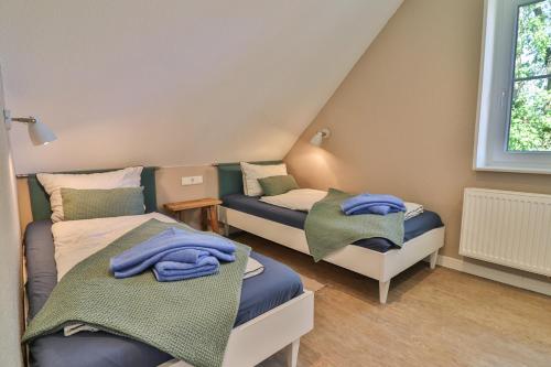 ein Zimmer mit 2 Betten und Handtüchern darauf in der Unterkunft Bi'n Eekboom in Langeoog
