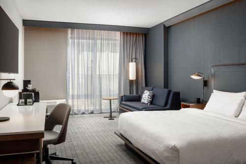 a hotel room with a bed and a desk and a chair at Courtyard by Marriott Cleveland in Cleveland