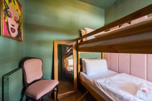 a small room with two bunk beds and a chair at City Retreat, Spacious 4 Bed House, Games Room, Parking, Hot Tub & BBQ in Cardiff