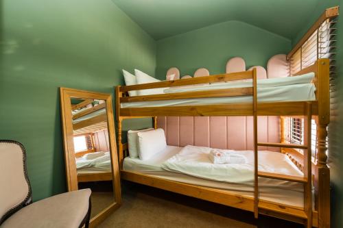two bunk beds in a room with a mirror at City Retreat, Spacious 4 Bed House, Games Room, Parking, Hot Tub & BBQ in Cardiff